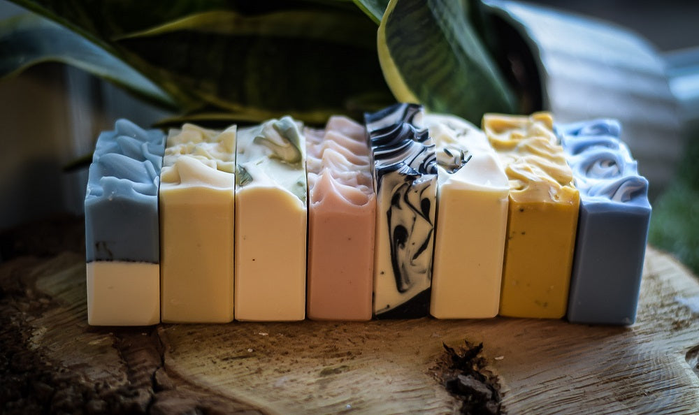 handmade soaps in a row on a piece of rustic wood